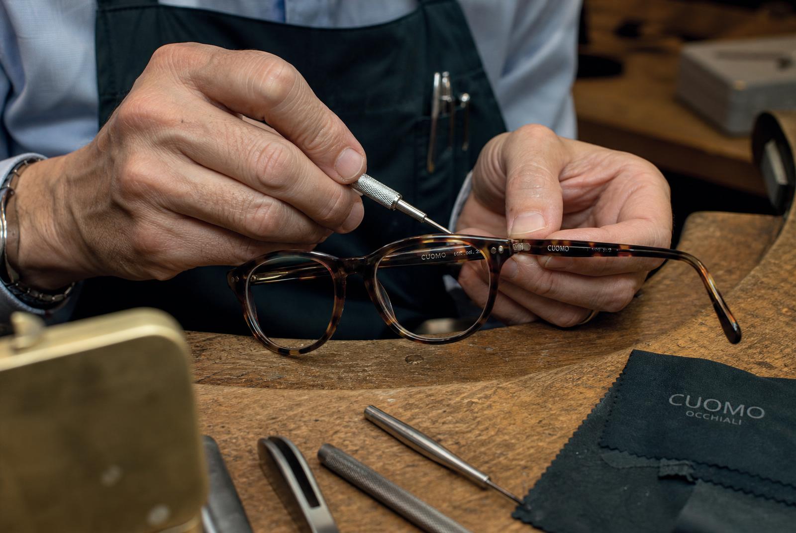 Master Optician adjusting eyeglass frames on a boutique workbench
